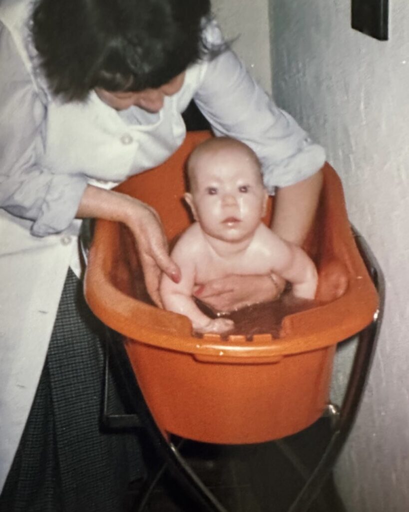 Eine Oma, die ein Säugling badet.